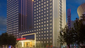 A high-rise hotel with a modern design, featuring a prominent entrance and multiple floors. - Wanda Realm Jining (Jining)