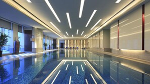 A modern hotel lobby with a long reflective pool, linear ceiling lights, and a minimalist design. - Wanda Vista Xining (Xining)