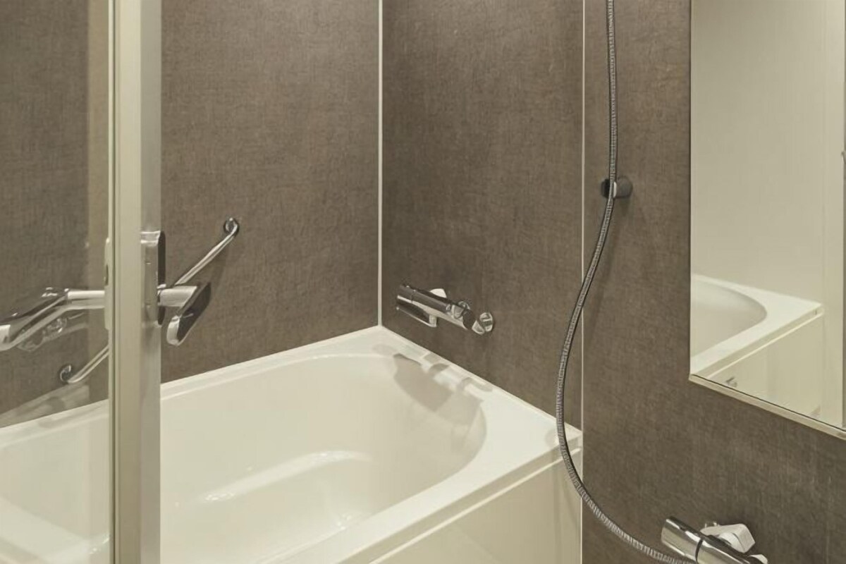 Un baño moderno con bañera, ducha y espejo.