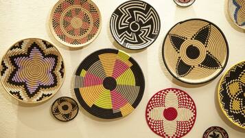 A collection of woven baskets with various patterns and sizes displayed on a wall.