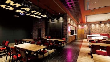 A restaurant interior with multiple dining tables and chairs, a brick wall, and a ceiling with circular light fixtures.