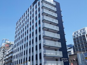 Un edificio de gran altura con varios balcones, un letrero que dice Daiwa Royal Hotel y el rótulo 