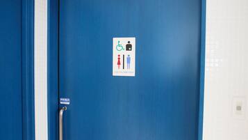 Une porte bleue, agréée pour l’accès aux personnes à mobilité réduite, et dotée d’une rampe.