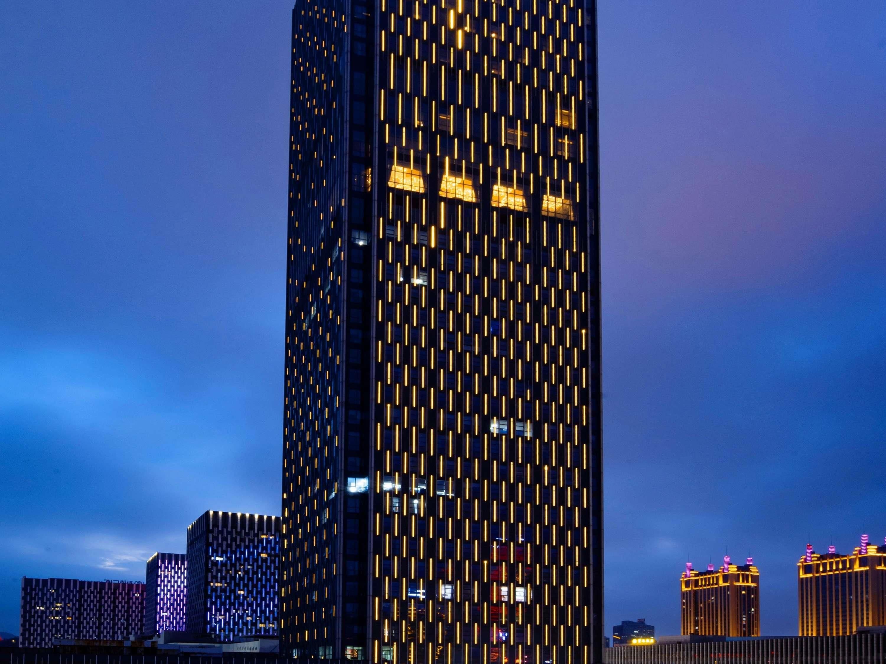A high-rise building with a distinctive vertical pattern of lights.