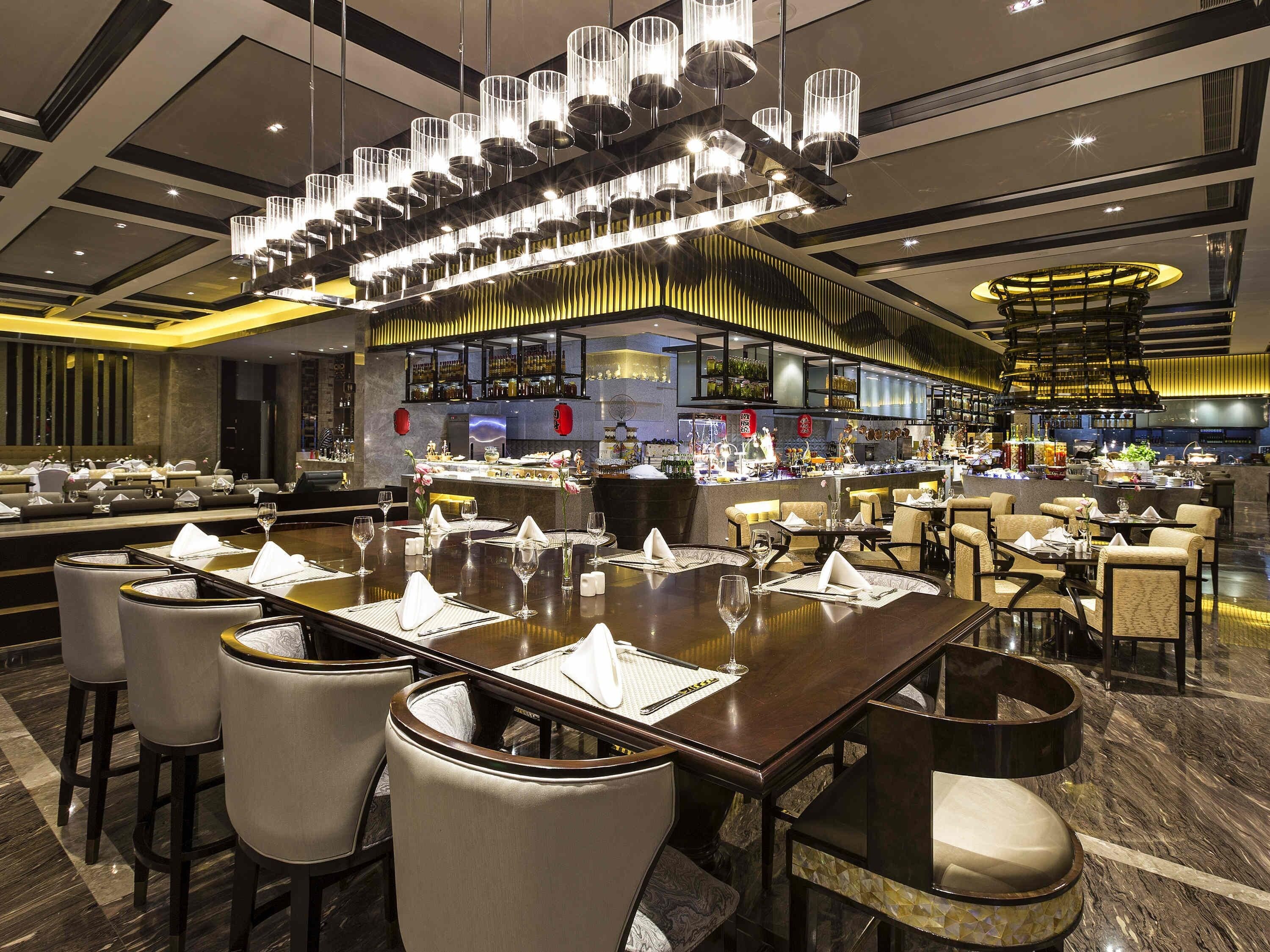 Un restaurante con varias mesas, sillas y una zona de bar.