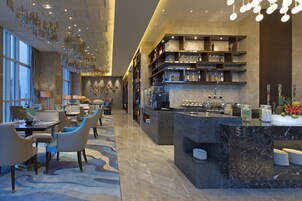 Un moderno vestíbulo de hotel con comedor, bar y recepción.