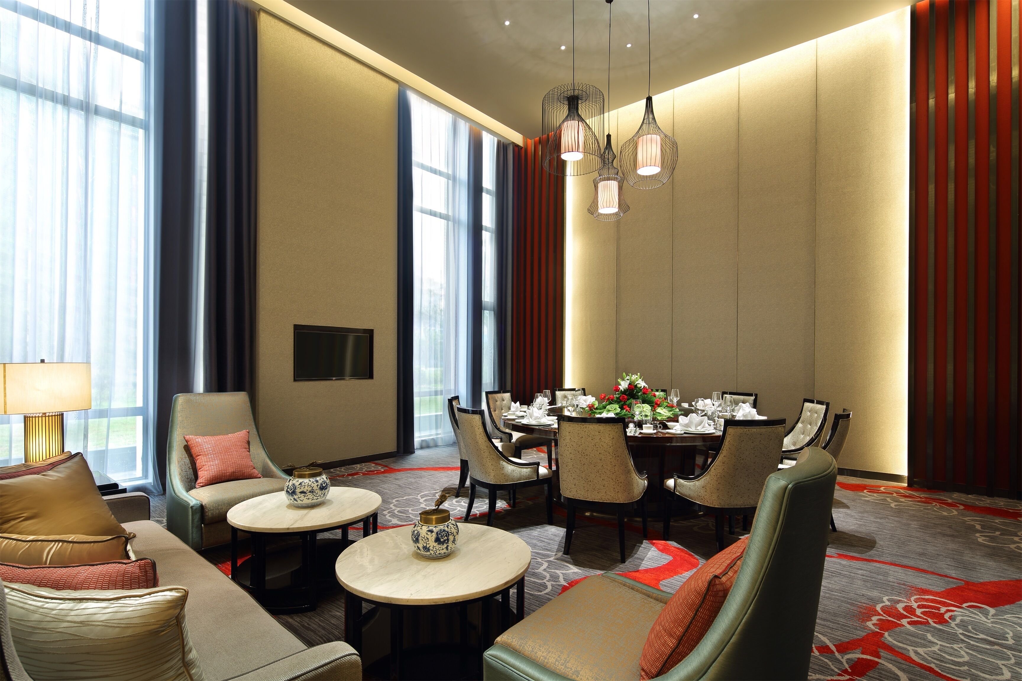 Un comedor de hotel con una mesa grande dispuesta para varios comensales, rodeada de asientos cómodos.