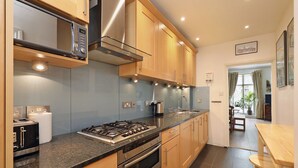 Une cuisine moderne dotée d’appareils électroménagers en acier inoxydable, d’armoires en bois et d’un plan de travail en granit.