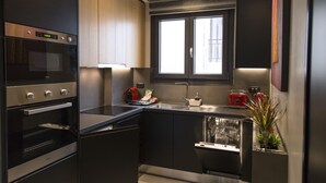 Cozinha moderna com eletrodomésticos embutidos, janela e uma planta.
