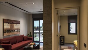 Uma sala de estar moderna com um sofá vermelho, uma mesa de centro e uma grande pintura abstrata na parede.