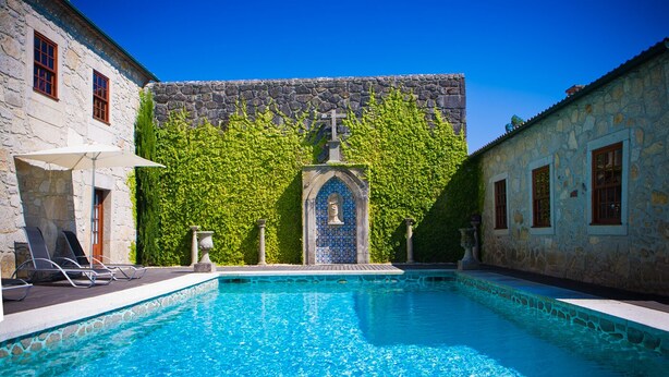 Una piscina con paredes de piedra y un arcoado de azulejos.