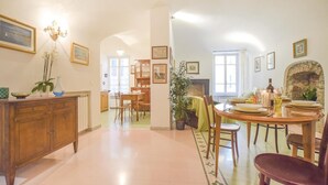 Une salle à manger spacieuse avec un plafond haut, des meubles en bois et une cheminée.