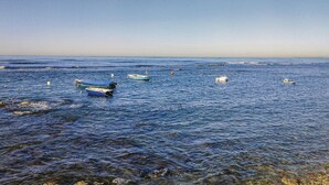 Une scène côtière avec plusieurs bateaux ancrés dans l’eau.