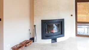 Un interior moderno con chimenea empotrada, un rincón y un ventanal grande.