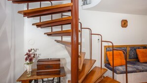 Un escalier en colimaçon avec des marches en bois et des rampes en métal, menant à un niveau inférieur.
