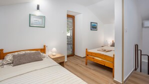 Une chambre à coucher avec deux lits en bois, une table de chevet, une lampe de chevet et un tableau encadré accroché au mur.