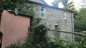 A stone building with a pink wall and a window. - Gîte au Moulin (Loft) Pets welcome!  (Naucelle)