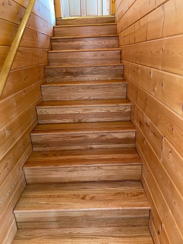A wooden staircase with a handrail, leading upwards. - Wild Thang – A great place to spend your Summer Vacation! (Pigeon Forge)