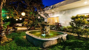 A well-maintained garden with a central fountain, surrounded by various plants and trees. - BIG! 3BR Home Fully Equipped, Pool, Gardens & WiFi (El Cedral)