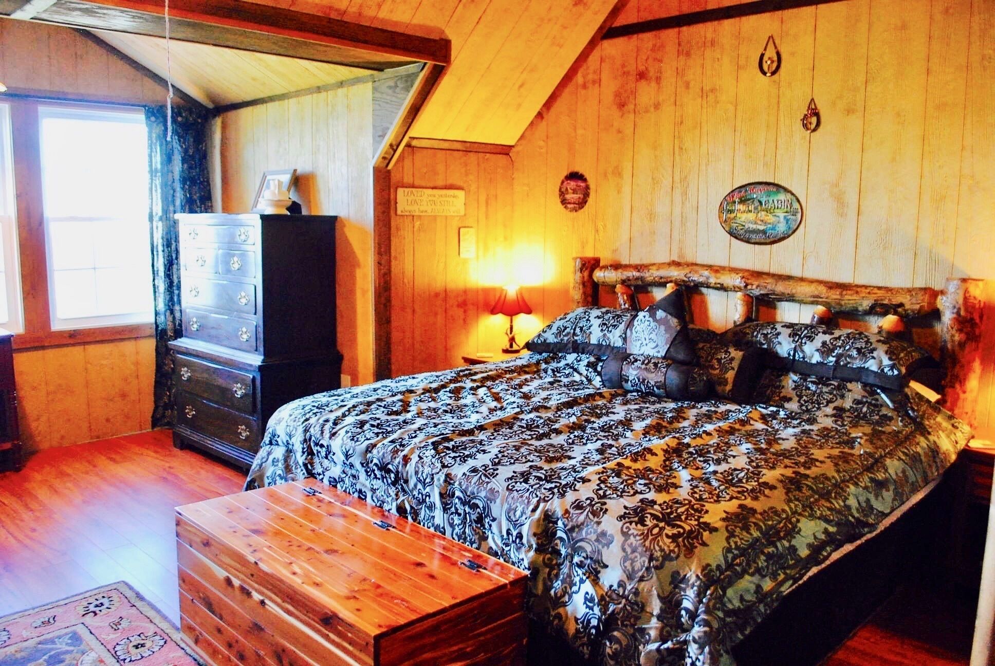 Un dormitorio acogedor con cama, cómoda y aparador de madera.