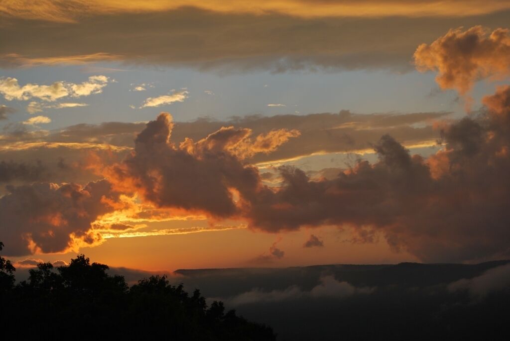 Un atardecer sobre un paisaje montañoso con nubes.