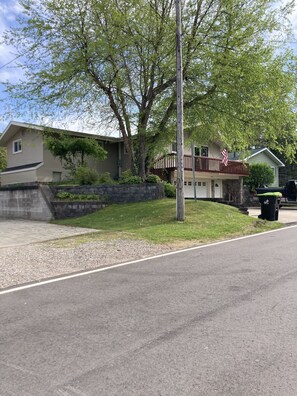 Une rue résidentielle bordée de maisons, avec un drapeau et un lampadaire.