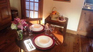 Ein Esstisch mit Tellern, Besteck und einer Blumenvase.