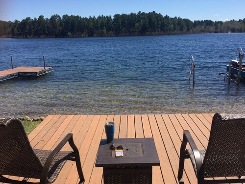 Northwoods lake home with gentle slope to clear lake with sandy beach