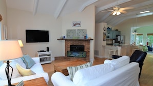 A living room with a fireplace, a sofa, a coffee table, and a TV. - 4 Bedroom, Community Pool!  517 Doral Drive, Bethany West (Bethany Beach)