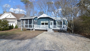 A two-story house with a covered porch and a gravel driveway. - 4 Bedroom, Community Pool!  517 Doral Drive, Bethany West (Bethany Beach)