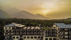 A multi-story hotel with balconies, a sign reading "Memories," and a view of mountains in the background. - D'Polo Club And Spa Resort, Dharamshala (Dharamshala)
