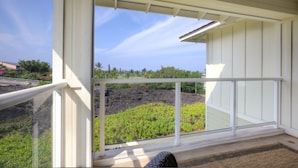 Un balcón con vista a un jardín ajardinado y un paisaje volcánico.