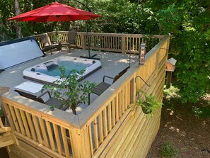 The hot tub is located on the deck outside Bluebirds Nest and one level up.