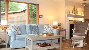 A cozy living room with a light blue sofa, a wooden coffee table, and a patterned armchair. - Beautiful Views, Sunrises, Dog Friendly, Comfortable! (Penn Yan)