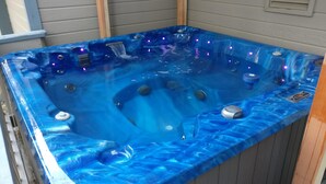 A hot tub with a blue marble finish, built-in jets, and LED lights. - Huge 7BR/4.5BA - Hot Tub, Ping Pong/Pool Table, Arcade, Gas BBQ (South Lake Tahoe)