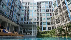 A modern building with multiple balconies, a swimming pool, and a glass entrance. - The Kith Plus Sukhumvit 113 (Samut Prakan)