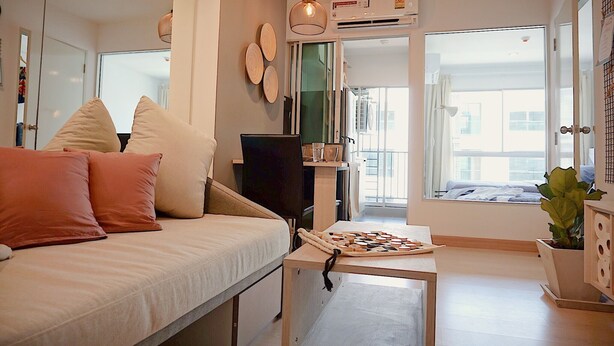 A modern living room with a sofa, a coffee table, and a large window. - The Kith Plus Sukhumvit 113 (Samut Prakan)