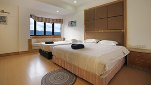 A hotel room with a large bed, a window with a view, a bedside table, and a headboard. - 1st Choice Vacation Apartments at Marina Court Resort Resort (Kota Kinabalu)