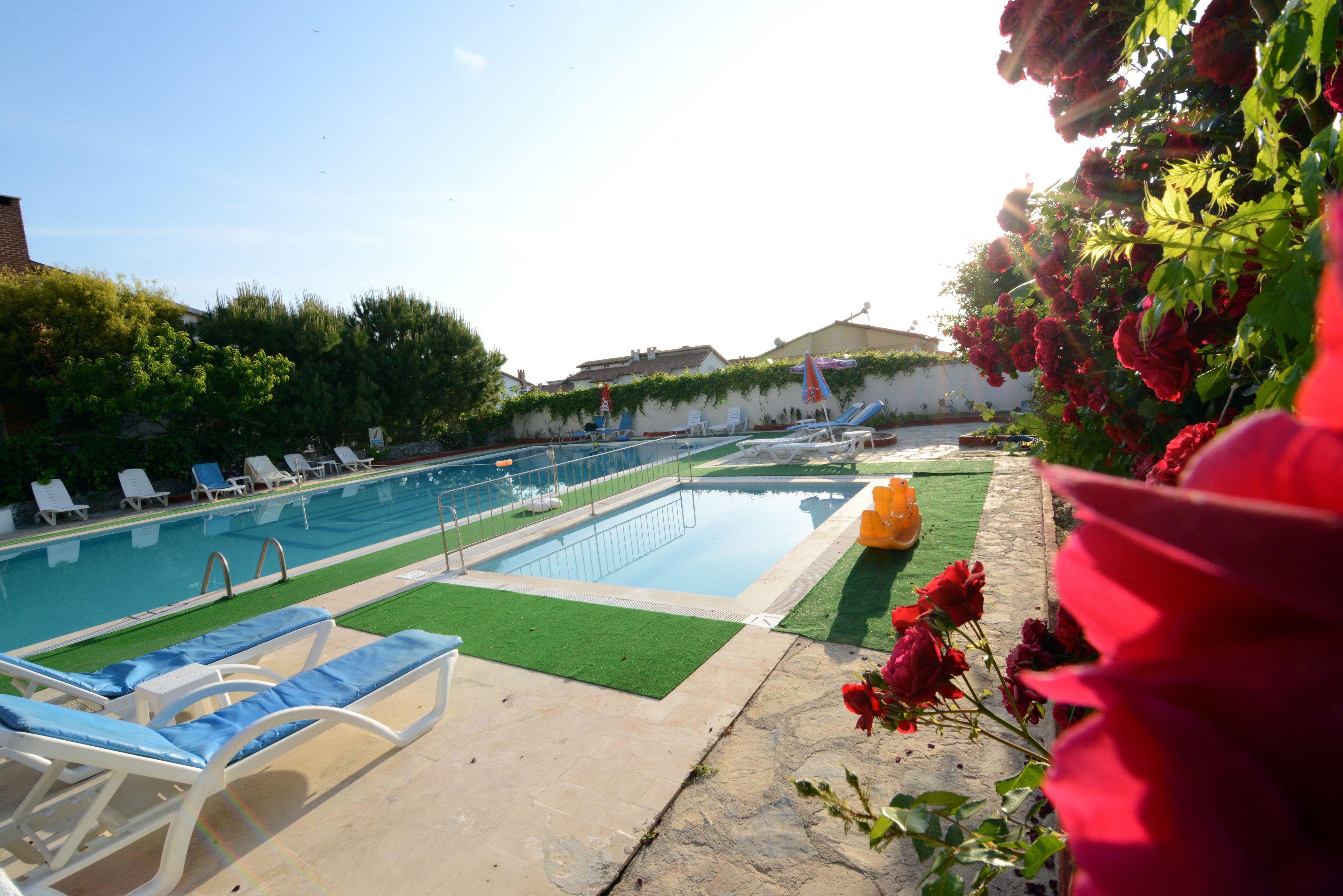 A swimming pool with lounge chairs and a small garden area with flowers.