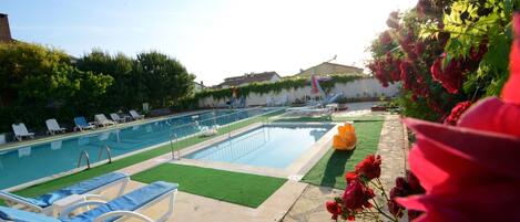 A swimming pool with lounge chairs and a small garden area with flowers.