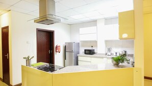 A modern kitchen with a central island, stainless steel appliances, and a microwave.