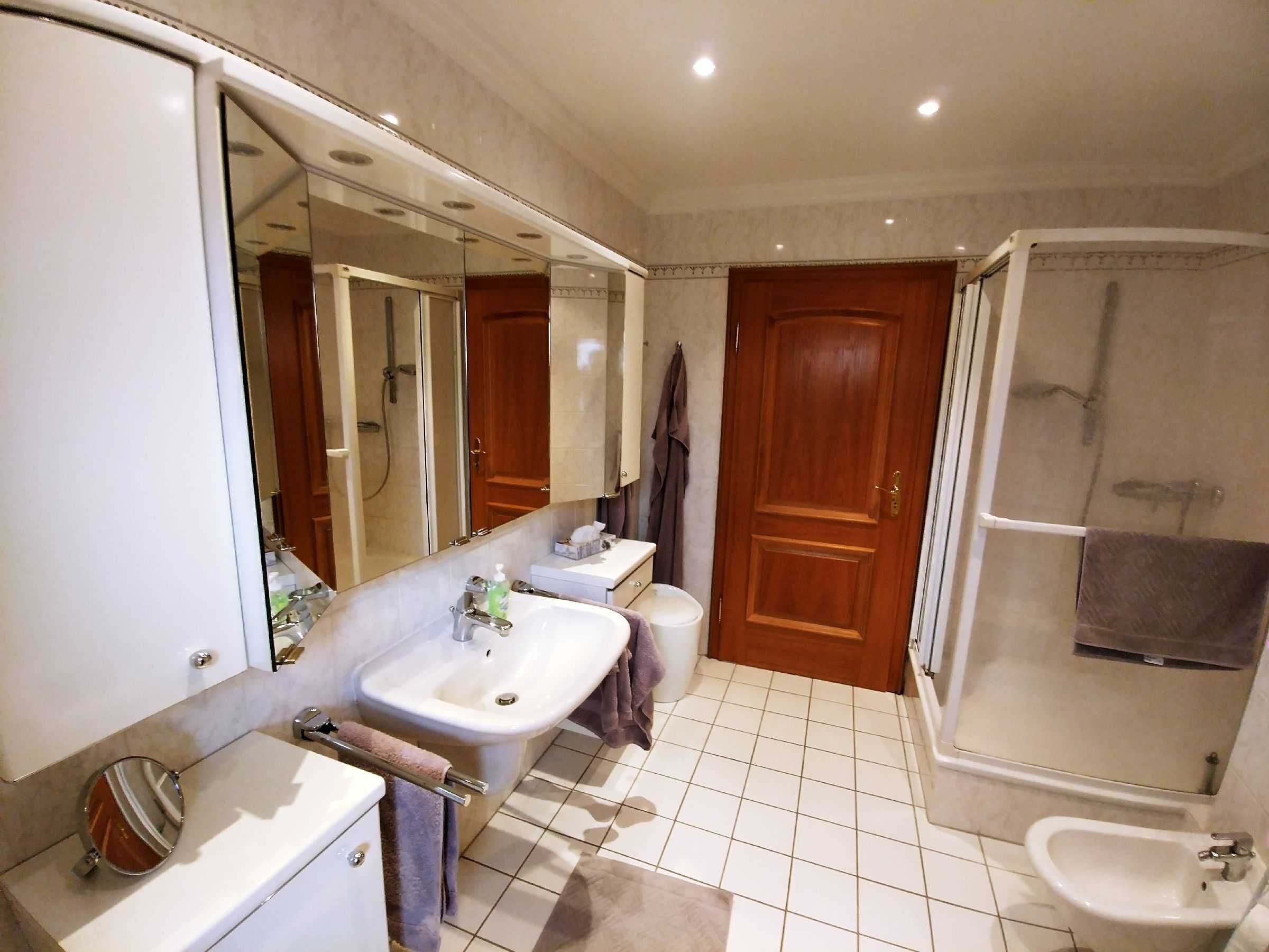 Une salle de bain équipée d’un lavabo, d’un miroir, de toilettes et d’une douche.