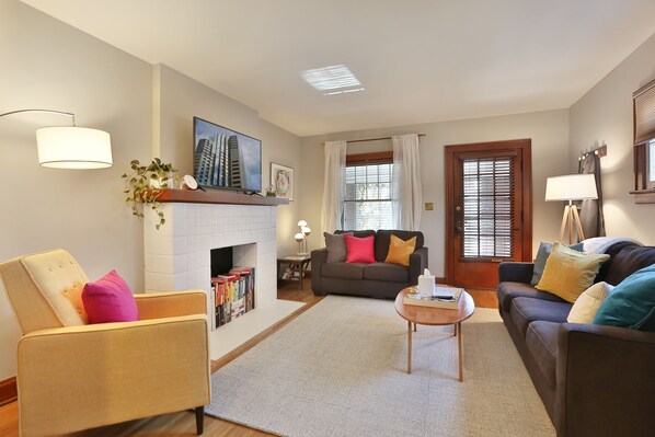 A living room with a fireplace, a sofa, a coffee table, and a chair.