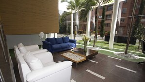 A modern lobby with a white sofa, a blue sofa, and a coffee table.