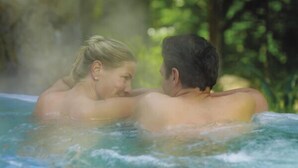 Two people in a hot tub surrounded by greenery. - Andelin Guest House (Auckland)