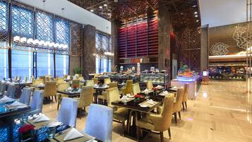 Un restaurant modern amb sostres alts, grans finestres i diferents disposicions de seients.