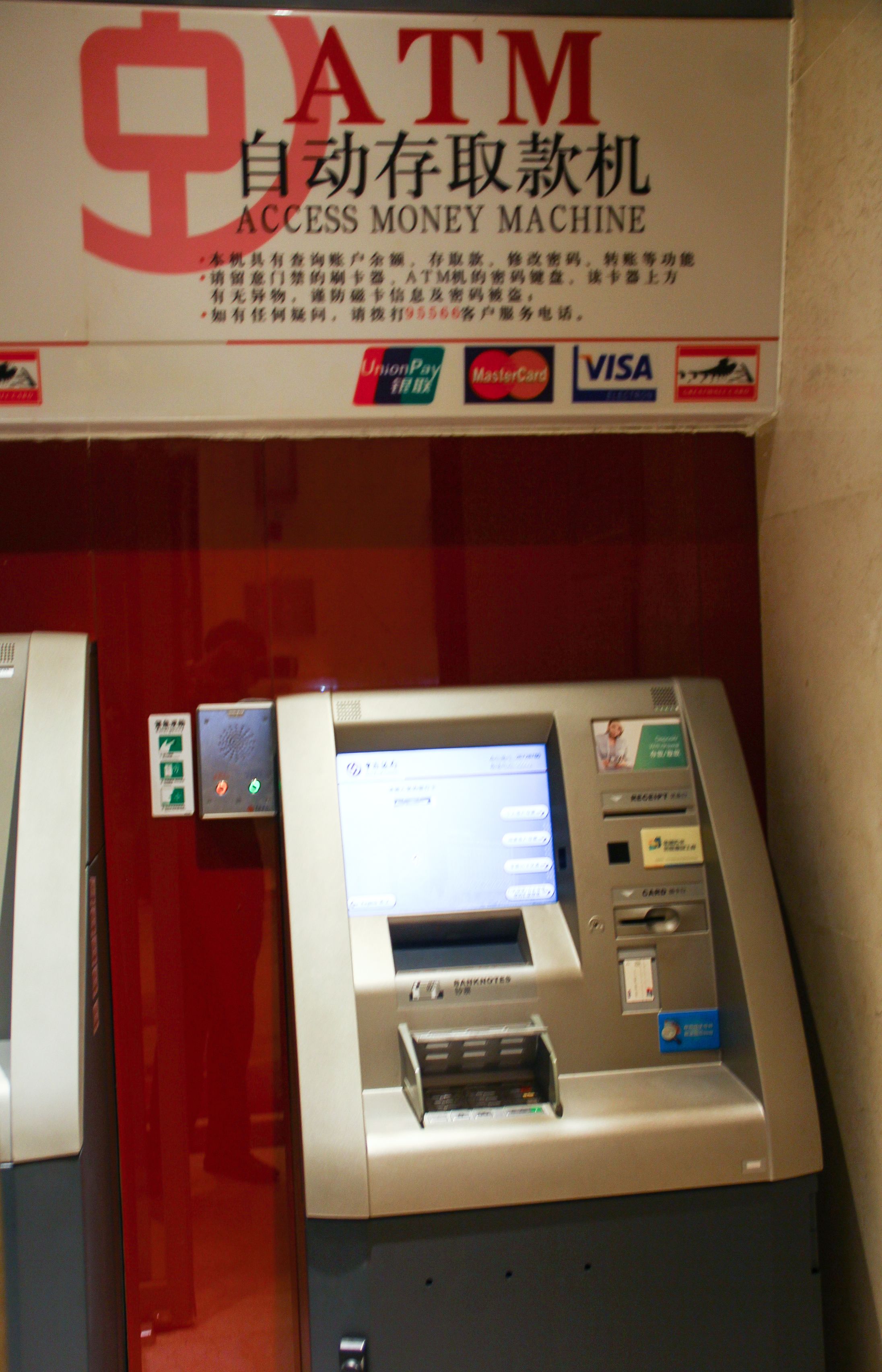 An ATM machine with a sign above it indicating it is an access money machine.