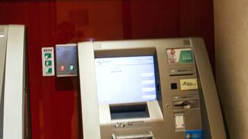 Un cajero automático con un cartel que indica que es una máquina de acceso a dinero.