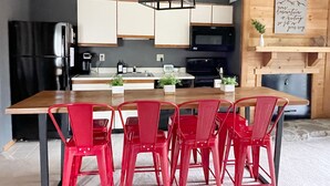 A modern kitchen with a wooden island, red chairs, and a black refrigerator. - Ultra-hip, Family-Friendly, Modern Space- SKI IN SKI OUT! (Champion)
