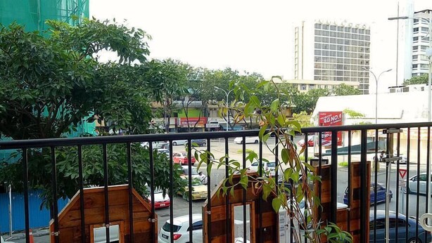 A balcony with a view of a city street, including cars and buildings. - HOOD - Hostel (Kota Kinabalu)